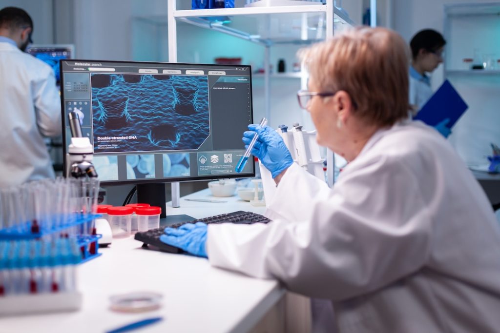 Biotechnologist senior scientist researching with test tube in pharma lab. Modern laboratory for scientific research with professional equipment for virus study and healtcare.